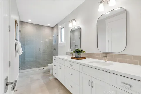 a bathroom with a double vanity sink mirror double and shower