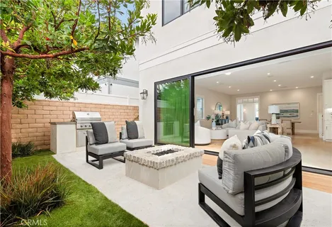 a living room with patio furniture and a potted plant
