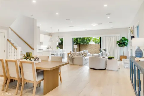 a dining room with furniture a large window and a kitchen view