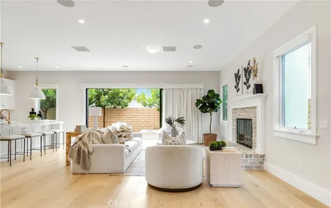 a living room with fireplace furniture and a large window