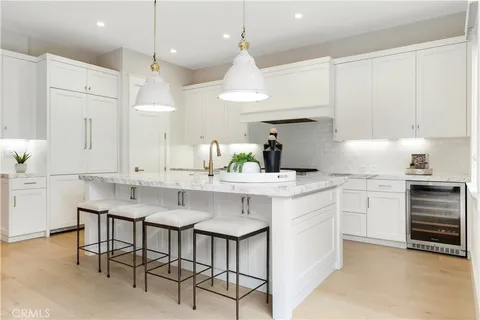 a kitchen with kitchen island granite countertop a sink a center island and cabinets