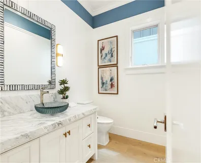 a bathroom with a granite countertop sink a toilet and a mirror