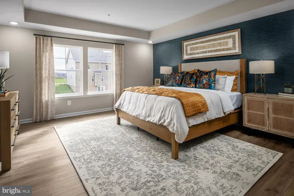 a bed sitting in a spacious bedroom next to a window