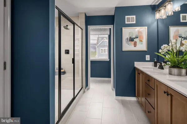 a bathroom with a granite countertop sink a mirror and a shower