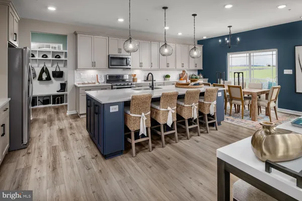 a large kitchen with cabinets a sink a counter and stainless steel appliances