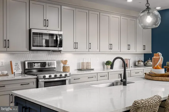 a kitchen with stainless steel appliances granite countertop a stove a sink dishwasher and a microwave with wooden cabinets