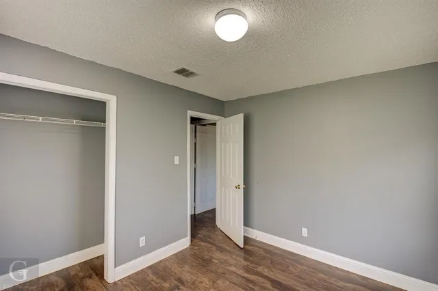 an empty room with wooden floor and closet