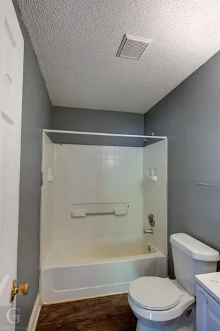 a bathroom with a toilet and a bath tub