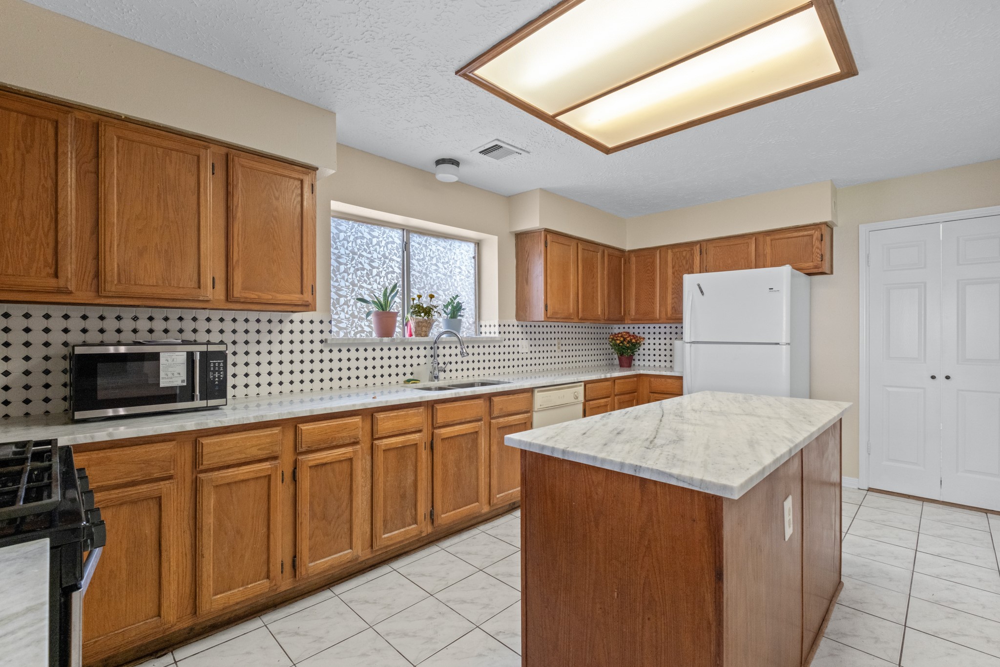 4131 Club Valley Drive Houston, TX 77082 - Photo 11 of 28 a kitchen with stainless steel appliances granite countertop a sink stove and refrigerator