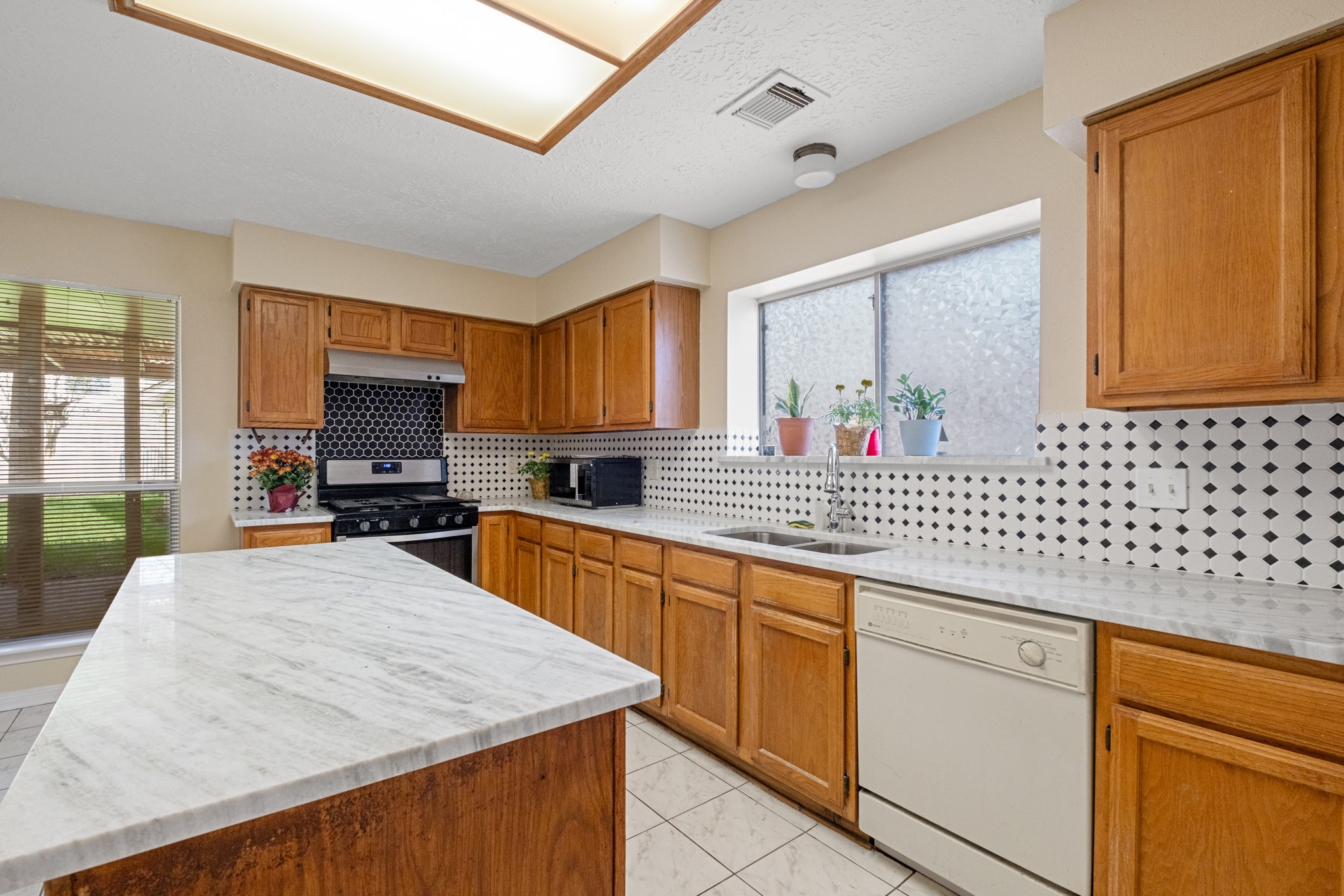 4131 Club Valley Drive Houston, TX 77082 - Photo 12 of 28 a kitchen with stainless steel appliances wooden cabinets a sink and a stove