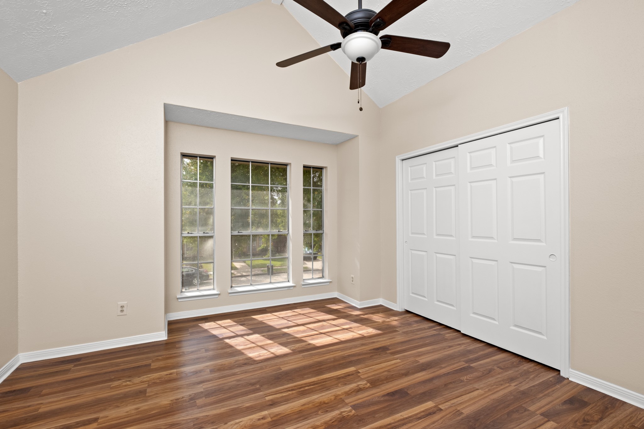 4131 Club Valley Drive Houston, TX 77082 - Photo 16 of 28 an empty room with wooden floor fan and windows