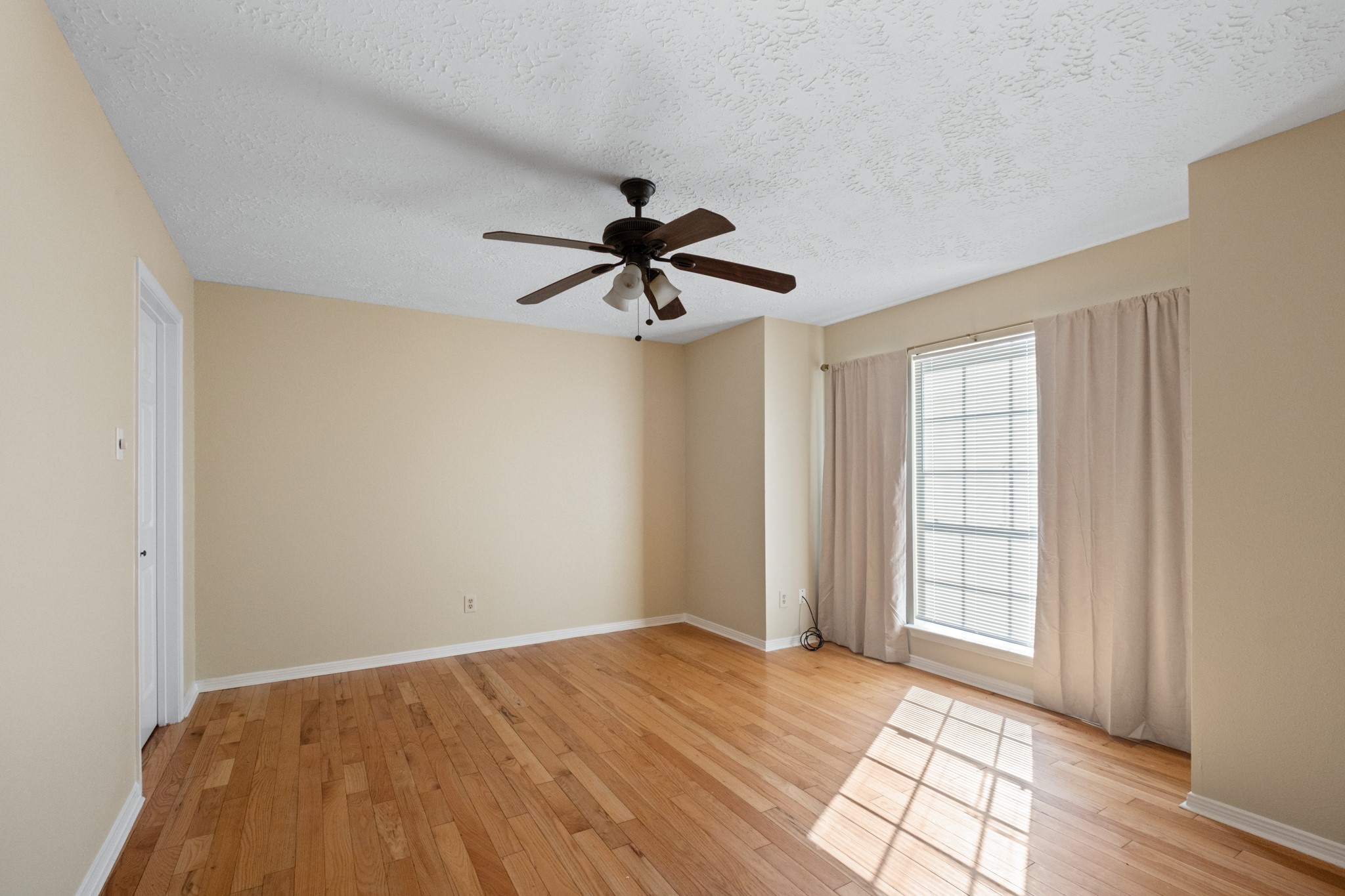 4131 Club Valley Drive Houston, TX 77082 - Photo 6 of 28 a view of empty room with wooden floor and fan