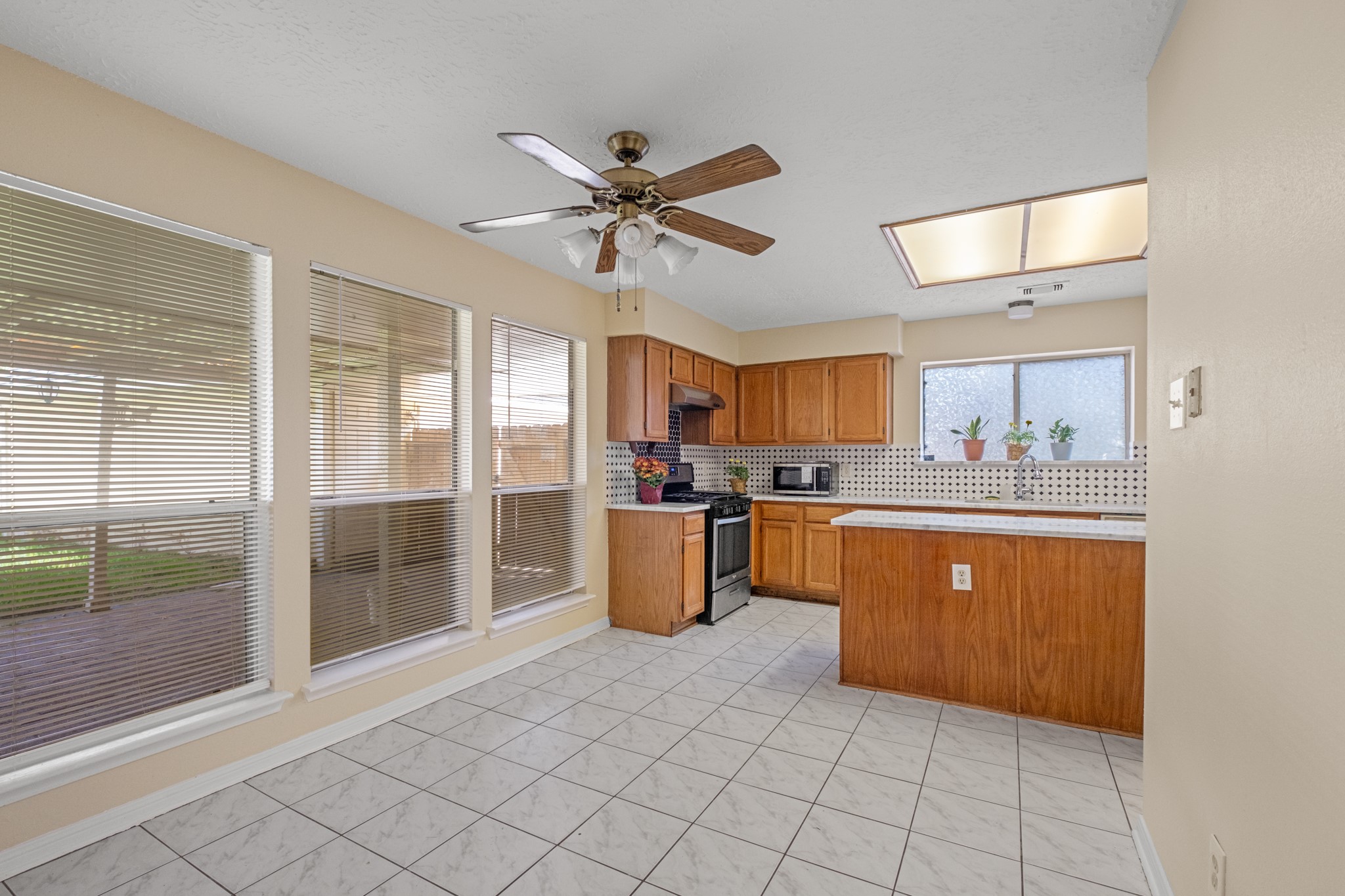 4131 Club Valley Drive Houston, TX 77082 - Photo 9 of 28 a kitchen with stainless steel appliances granite countertop a refrigerator a sink a stove and white cabinets