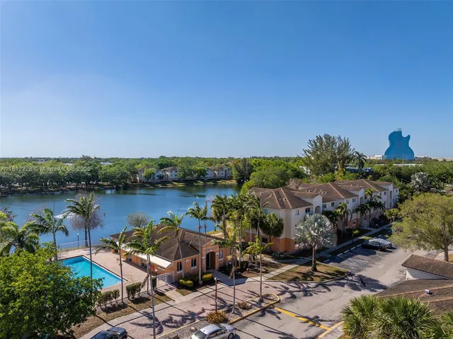 a view of a lake with lawn chairs and wooden fence