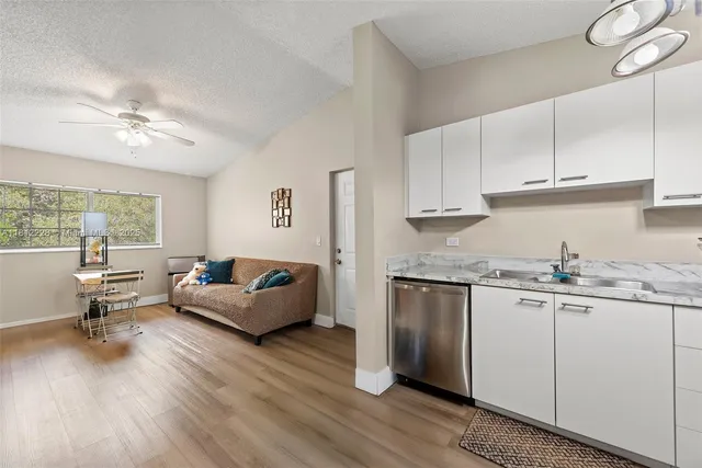 a living room with granite countertop furniture and a kitchen view