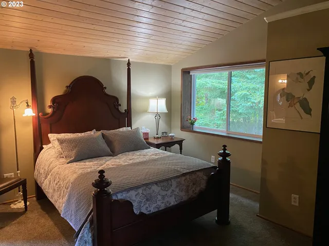 a bedroom with a bed and a large window