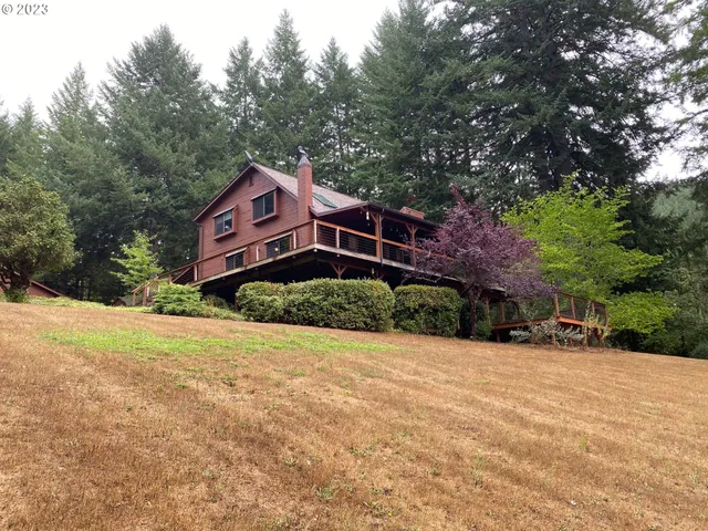 a view of a house with a yard and large trees