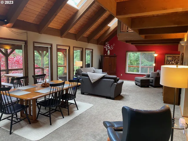 a living room with furniture a chandelier and a large window