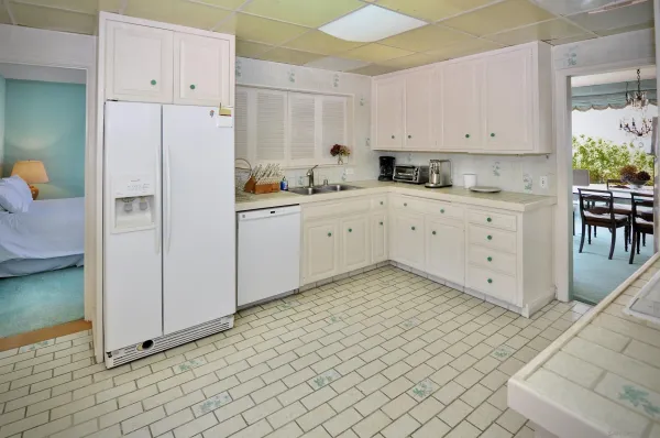 a kitchen with white cabinets and white appliances