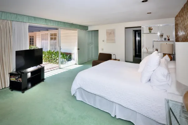 a spacious bedroom with a bed and a television
