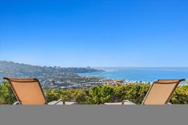 an aerial view of residential houses with outdoor space and ocean view