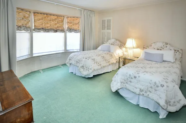 a bedroom with two beds and a large window