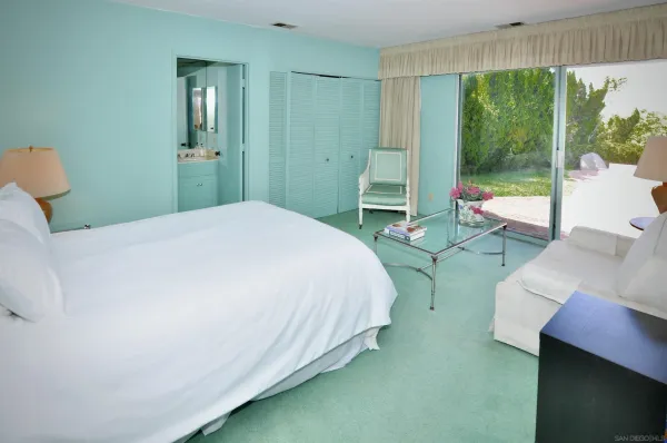 a spacious bedroom with a bed and large windows