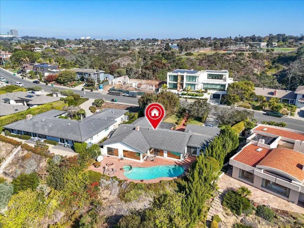 an aerial view of residential houses with outdoor space and parking