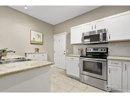 a kitchen with stainless steel appliances granite countertop a stove microwave and sink