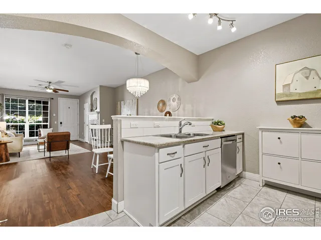 a kitchen with granite countertop a sink cabinets and wooden floor