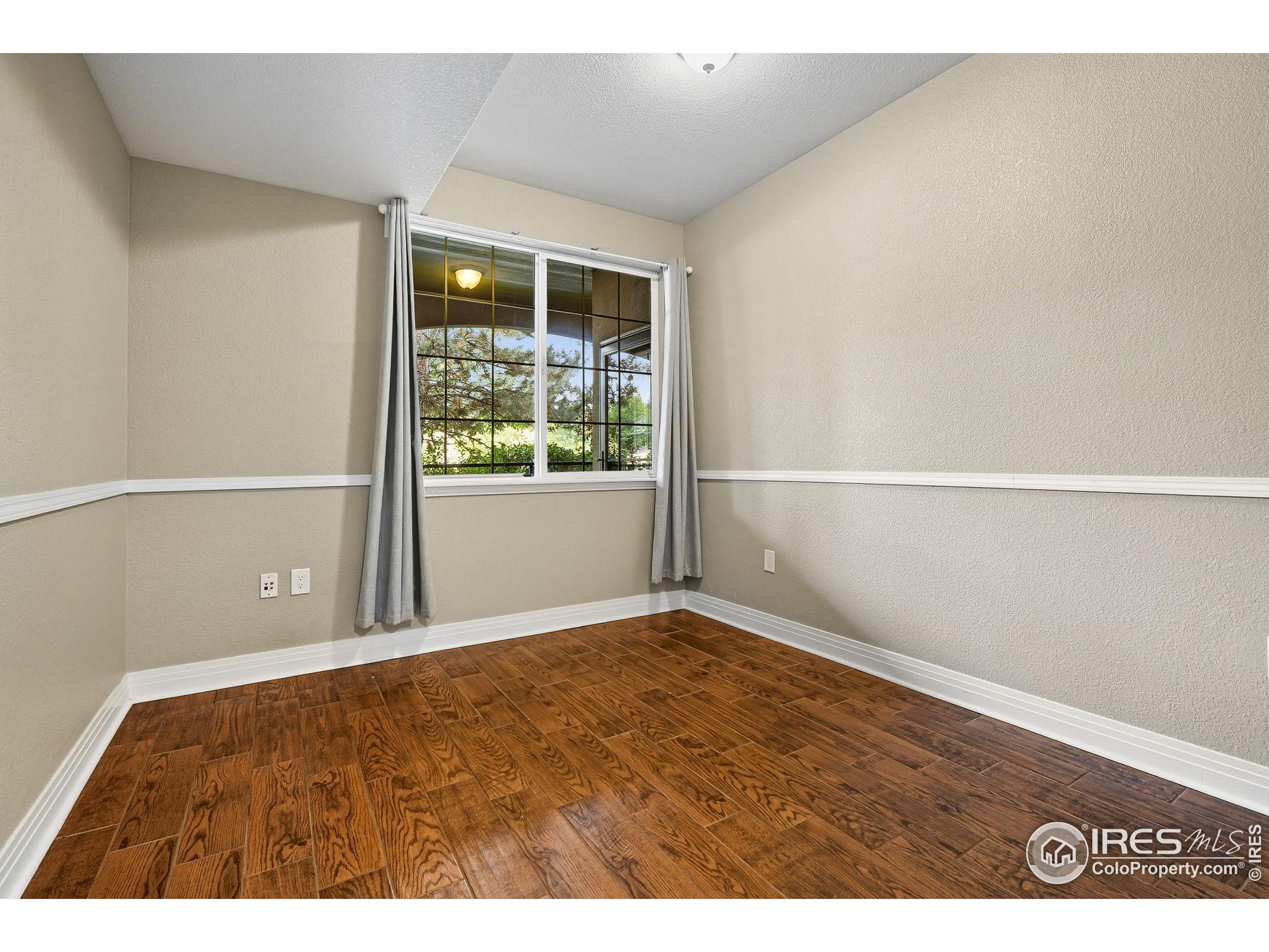 159 Quebec Street, Unit D Denver, CO 80220 - Photo 27 of 49 a view of an empty room with wooden floor and windows