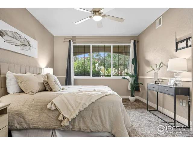 a bedroom with a large bed and a chandelier fan