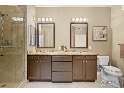 a bathroom with a granite countertop sink a toilet and a mirror