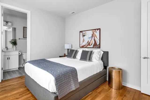 a bedroom with bed and wooden floor