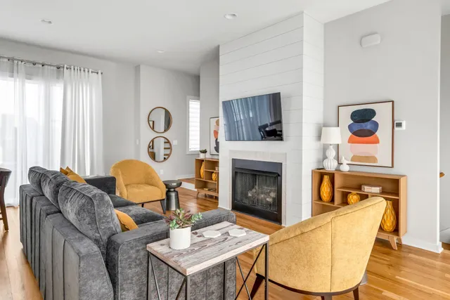 a living room with furniture a flat screen tv and a fireplace