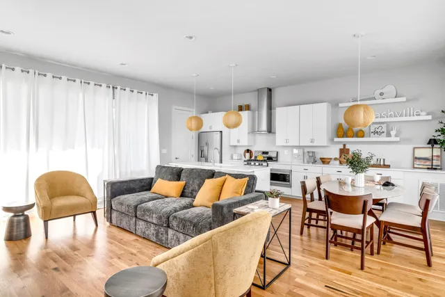 a living room with furniture kitchen view and a large window