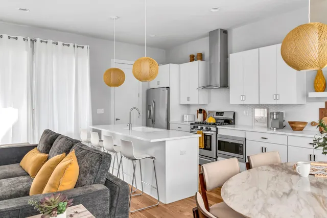 a kitchen with stainless steel appliances kitchen island granite countertop a table chair sink and cabinets