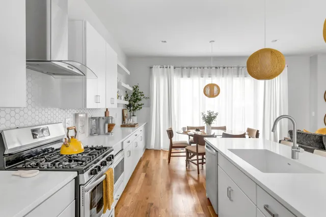 a kitchen with stainless steel appliances a stove a sink a cabinets and wooden floor
