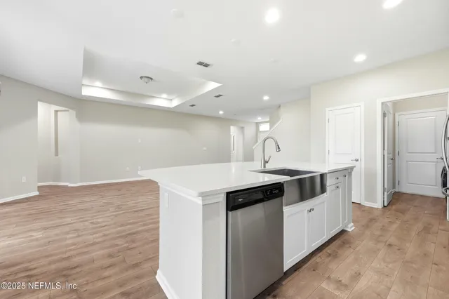 a kitchen with white cabinets and stainless steel appliances