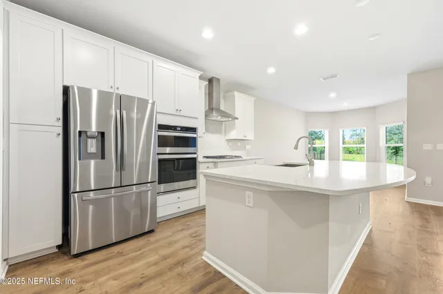 a kitchen with stainless steel appliances granite countertop a sink and a large window