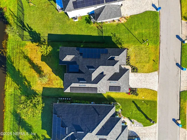 a view of a house with a yard potted plants and large tree