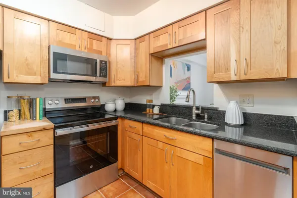 a kitchen with stainless steel appliances granite countertop a sink a stove and a microwave