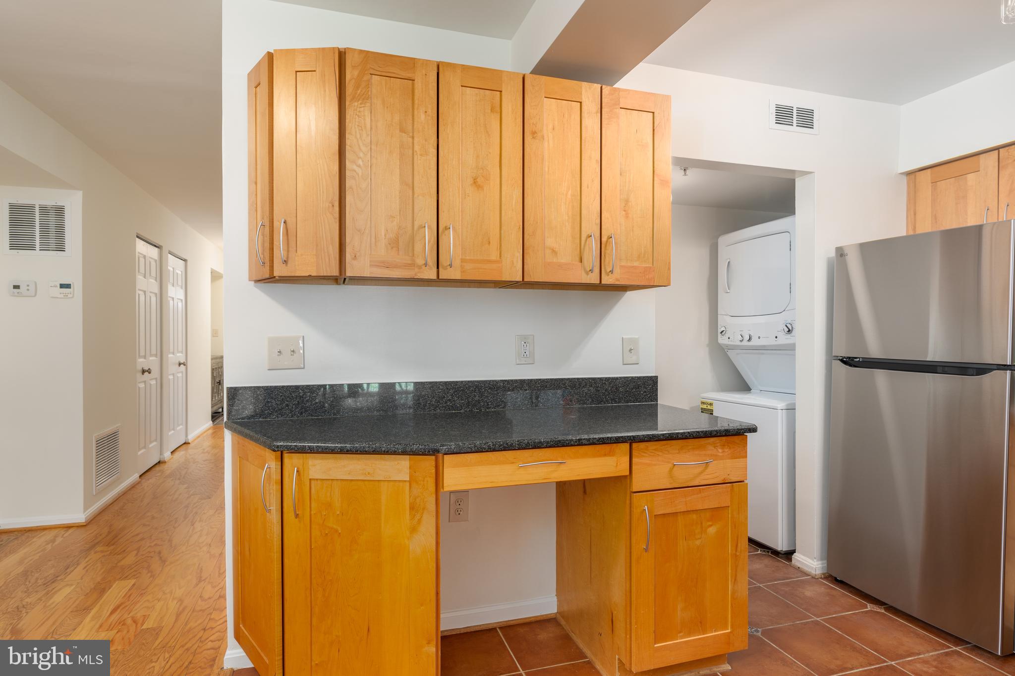 3806 Porter Street Northwest, Unit 101 Washington, DC 20016 - Photo 16 of 31 a kitchen with granite countertop cabinets and refrigerator