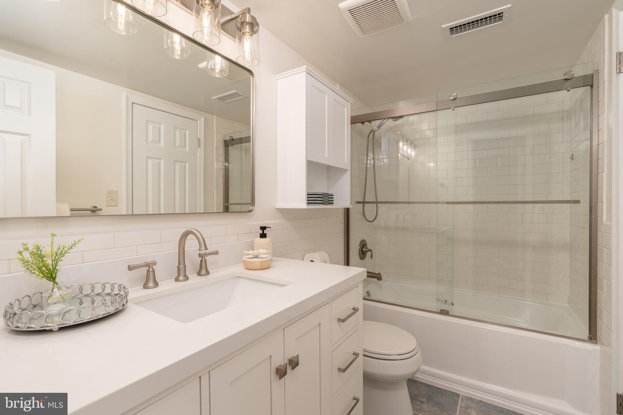 3806 Porter Street Northwest, Unit 101 Washington, DC 20016 - Photo 9 of 31 a bathroom with a sink a toilet and shower