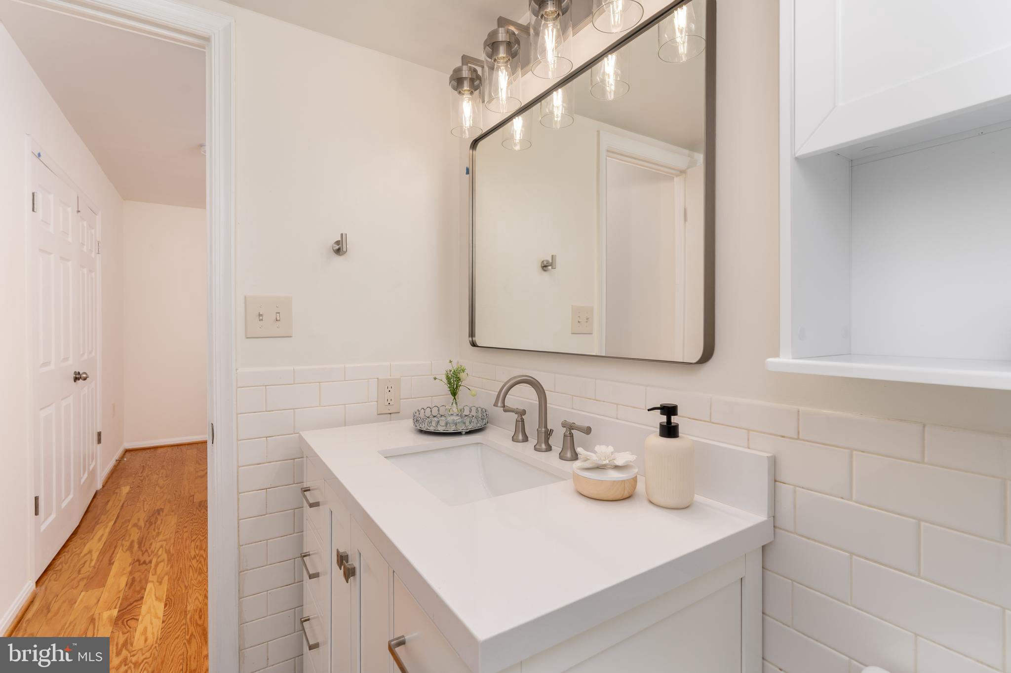 3806 Porter Street Northwest, Unit 101 Washington, DC 20016 - Photo 10 of 31 a bathroom with a sink and a mirror
