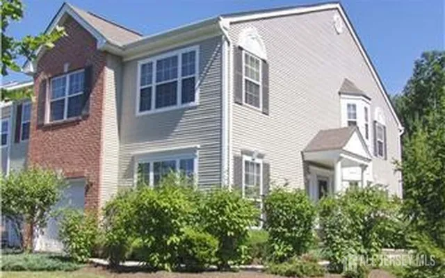 a view of a house with a yard and potted plants