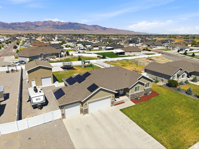 664 South Saddle Road Grantsville, UT 84029 - Photo 2 of 78 Single-story residence featuring a two-car garage, an additional detached single-car garage, and a gravel-paved side yard with white vinyl fencing