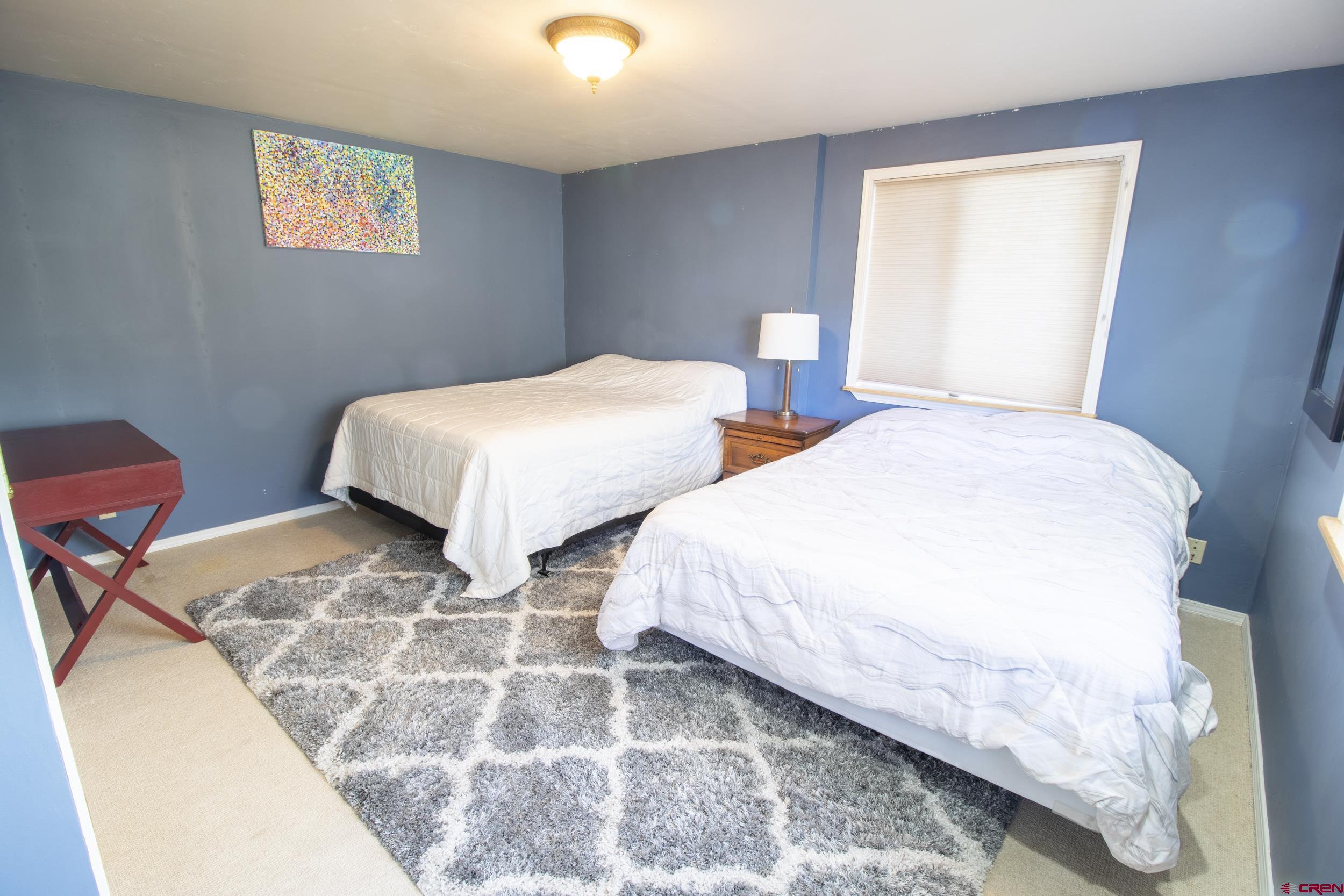 198 Spring Creek Drive Durango, CO 81301 - Photo 22 of 39 a bedroom with two beds lamp and a window
