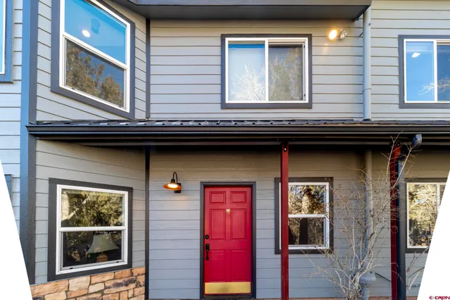 a bedroom with a bed a dresser and a chandelier