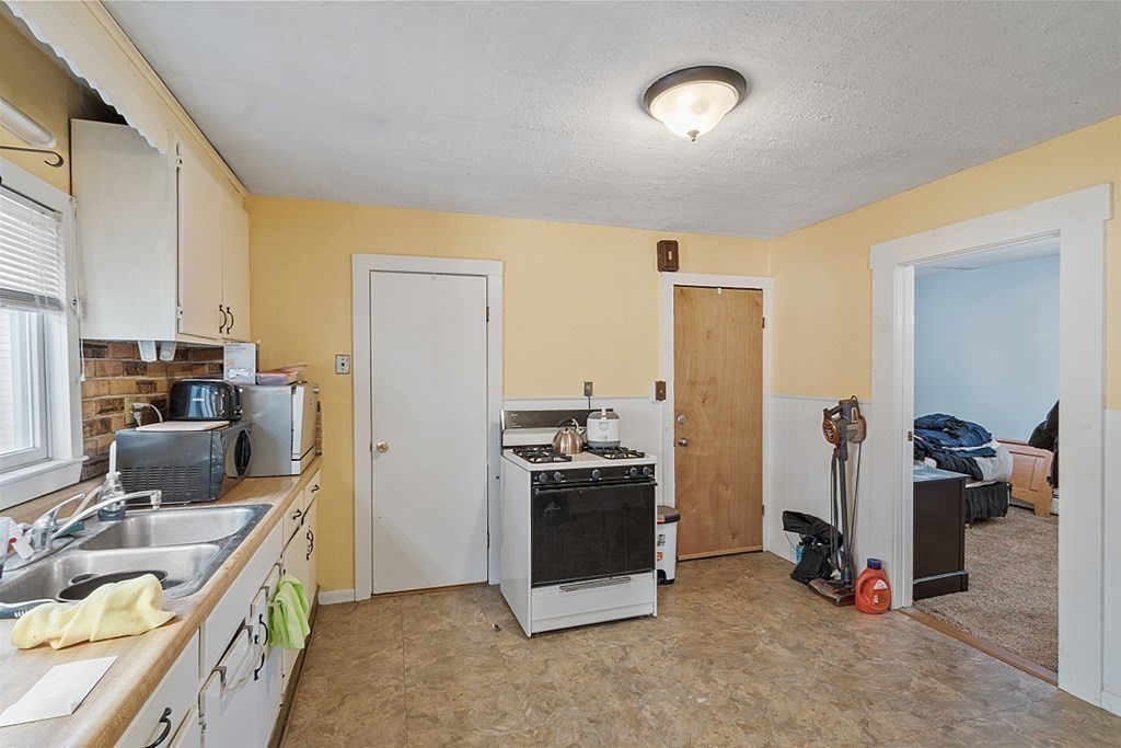 11 Autumn Street Lowell, MA 01852 - Photo 29 of 35 a kitchen with stainless steel appliances granite countertop a sink stove and refrigerator
